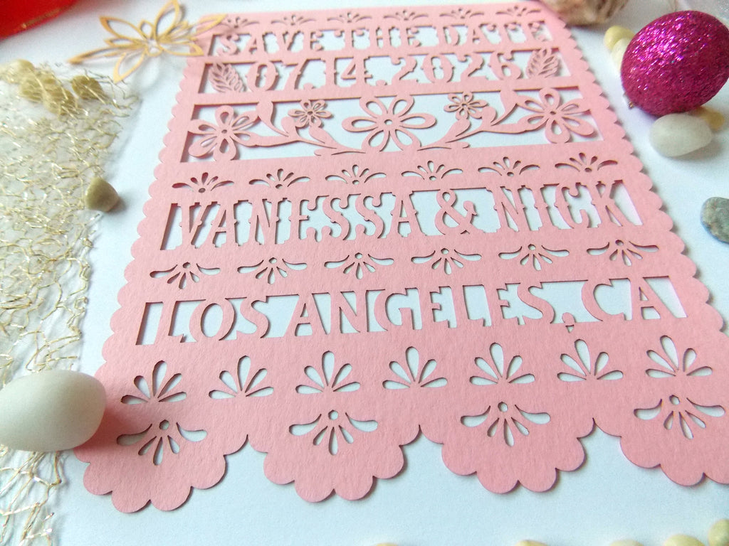 Pink  papel picado Save the Date card with floral cutouts on a decorative background